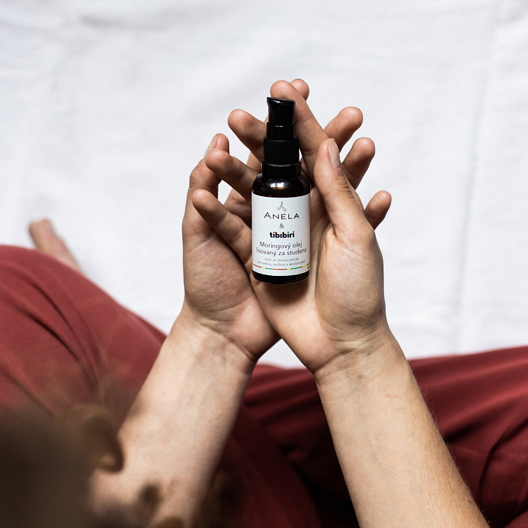 ruce držící moringový olej, pohled z vrchu