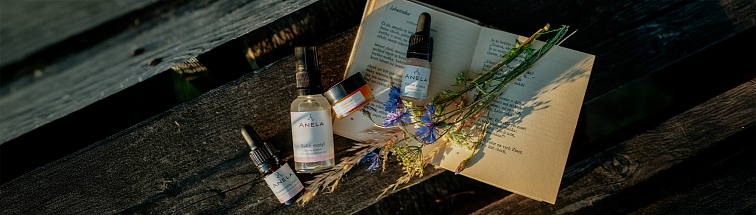 pleťová kosmetika vhodné pro citlivou pleť, produkty s trsem lučních květin jsou položené na knížce.