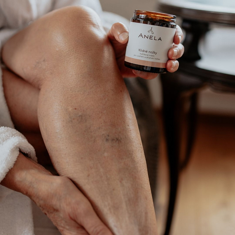 ženská ruka nanášející na nohu šlehané máslo Klidné nožky