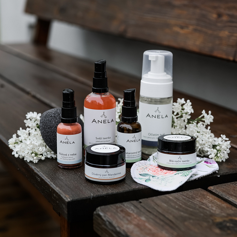 pleťová kosmetika z řady na problematickou pleť, na černém tácu, okolo bíle květiny