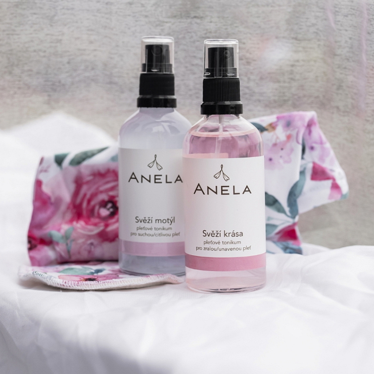 dvě pleťové tonika, v pozadí látka s květy