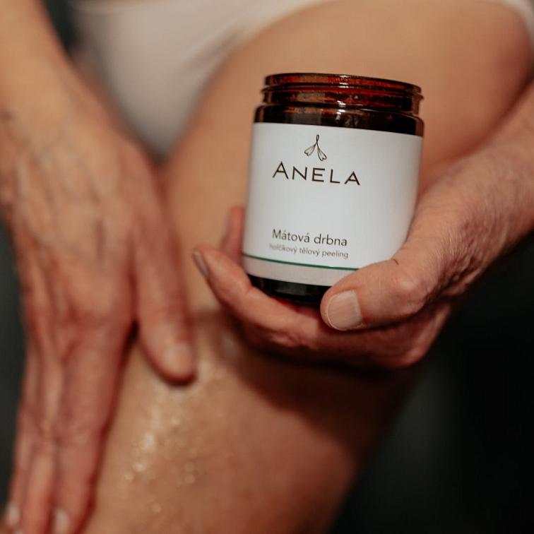 ruka aplikující peeling mátová drba na nohu