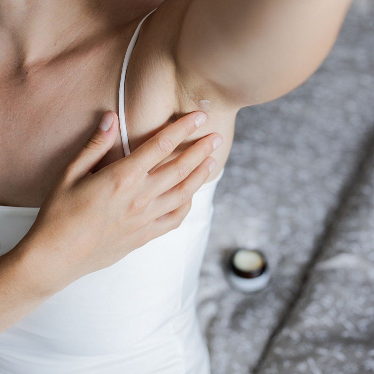 ruka nanášející do podpaží Přírodní deodorant bez hliníku Důvěrný pan Mandarinka