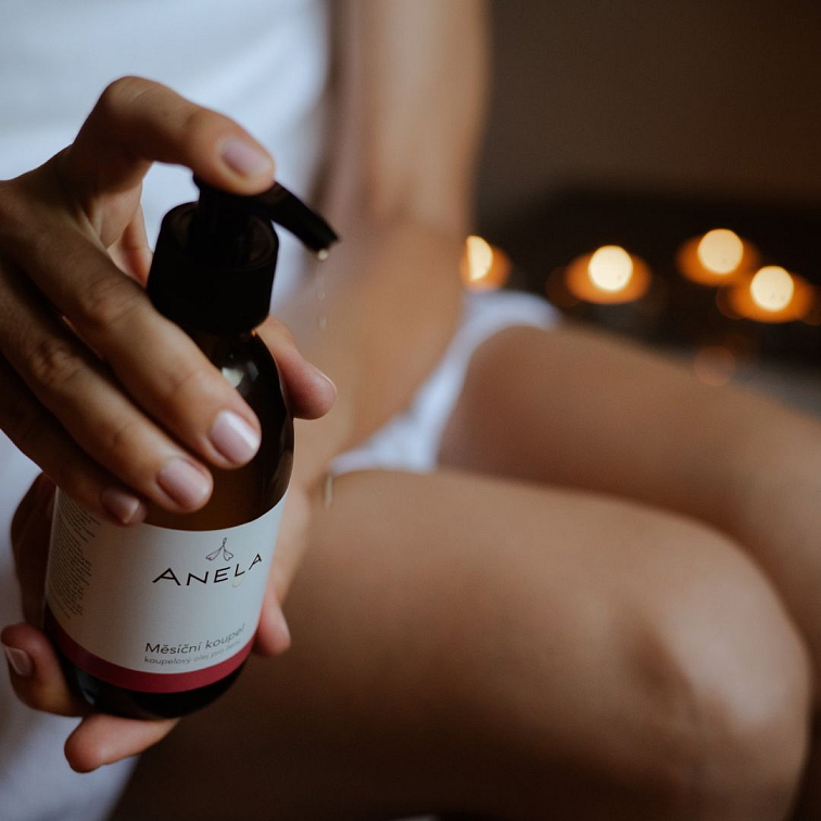 ženská ruka dávkující do vody Koupelový olej pro ženy během PMS