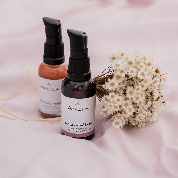 produkty - hydratační sérum a olejové pleťové sérum, v pozadí položená květina